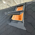 Exterior side view of the Twilight Pod showing the open VELUX roof window integrated into the curved shingle roof