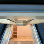 View looking into The Twilight Pod interior through the opened VELUX roof window, showcasing natural light and timber finish