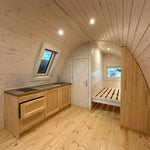 Wide interior view of The Twilight Pod displaying kitchenette, bathroom door, and sleeping area layout