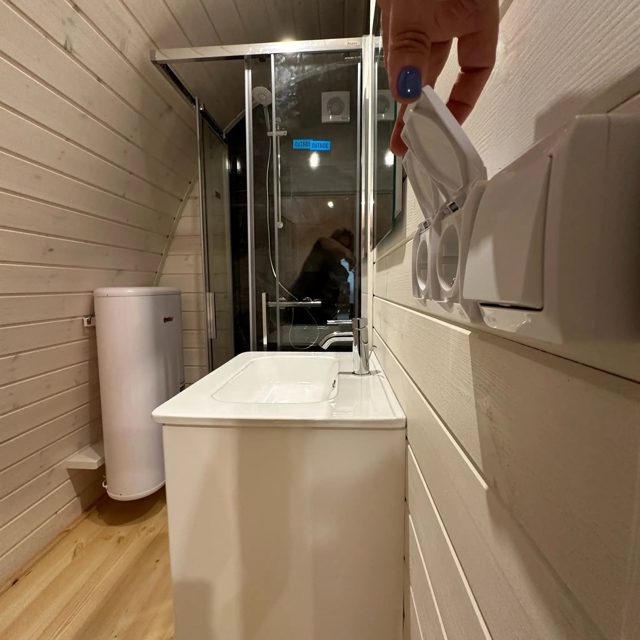 Interior bathroom view of The Twilight Pod showing shower enclosure, sink unit, and space-efficient glamping bathroom design