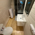 Compact bathroom interior of the Twilight Pod featuring toilet, sink unit, shower enclosure, and timber-lined walls