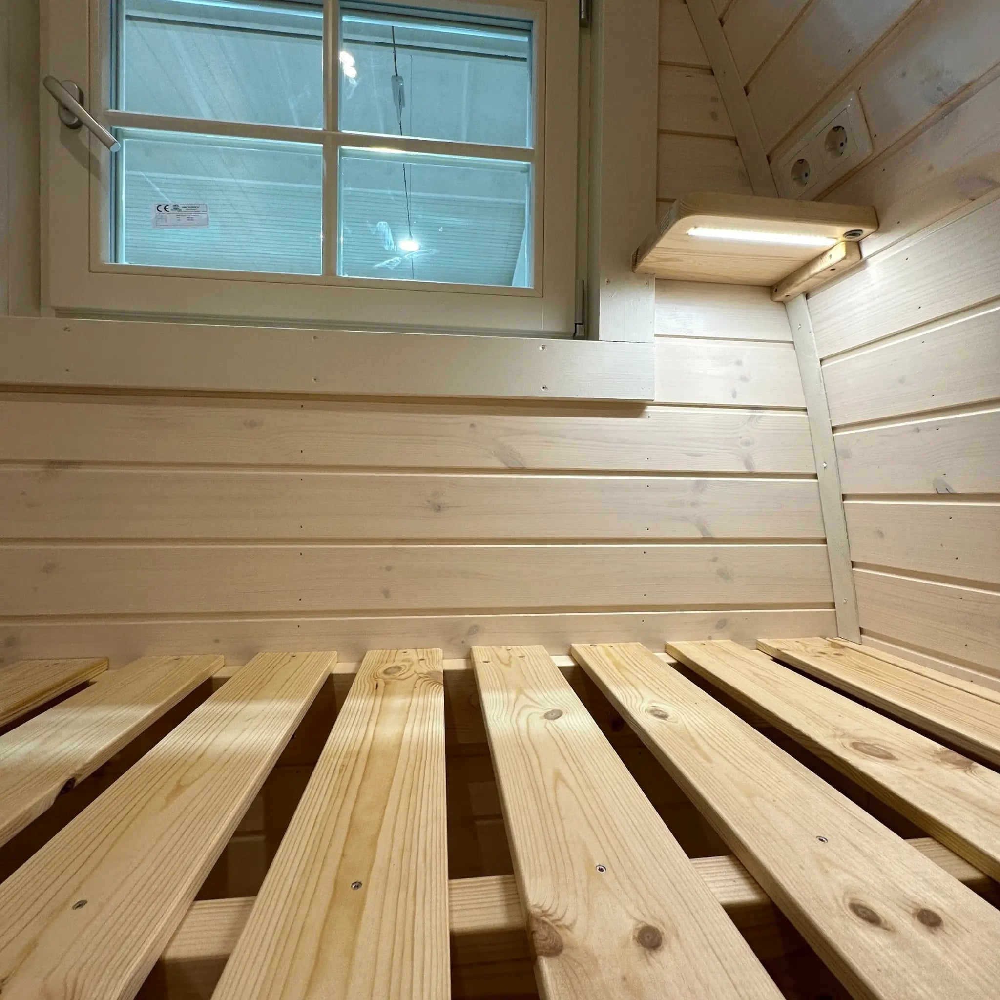 Close-up of timber bed frame inside the Twilight Pod showing solid wood construction and slatted base