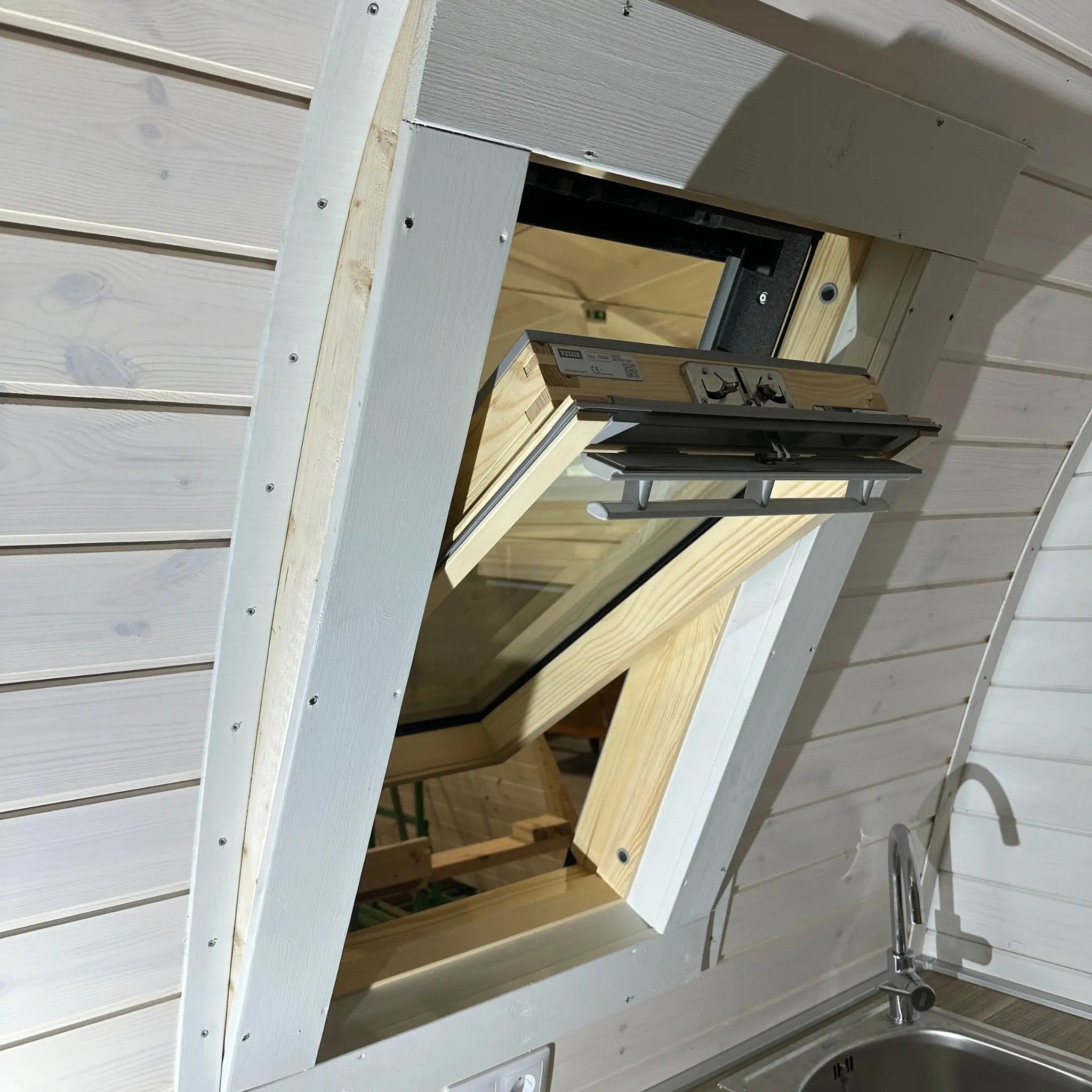 Interior detail showing VELUX roof window opened within the curved timber ceiling of the Twilight pod