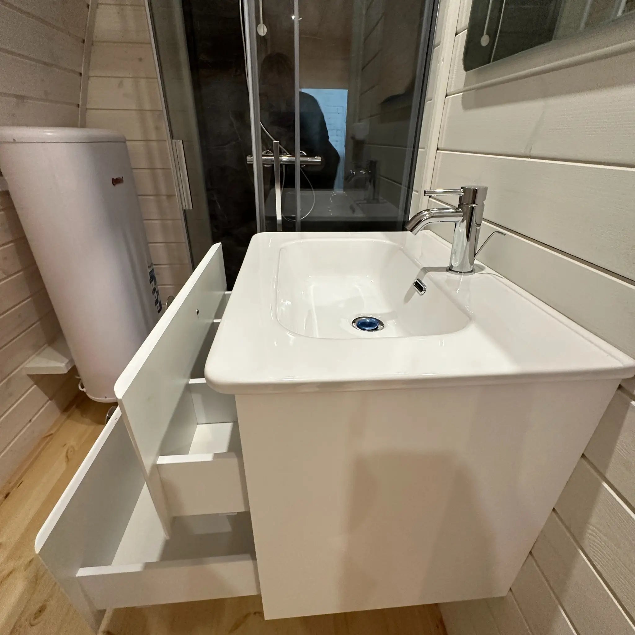 Side view of compact kitchen sink with drawers open showing storage inside the Twilight glamping pod