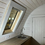 Interior view of kitchen counter with sink positioned beneath VELUX roof window in the Twilight pod