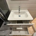 Top-down view of bathroom sink cabinet with drawers open showing internal storage in the Twilight glamping pod