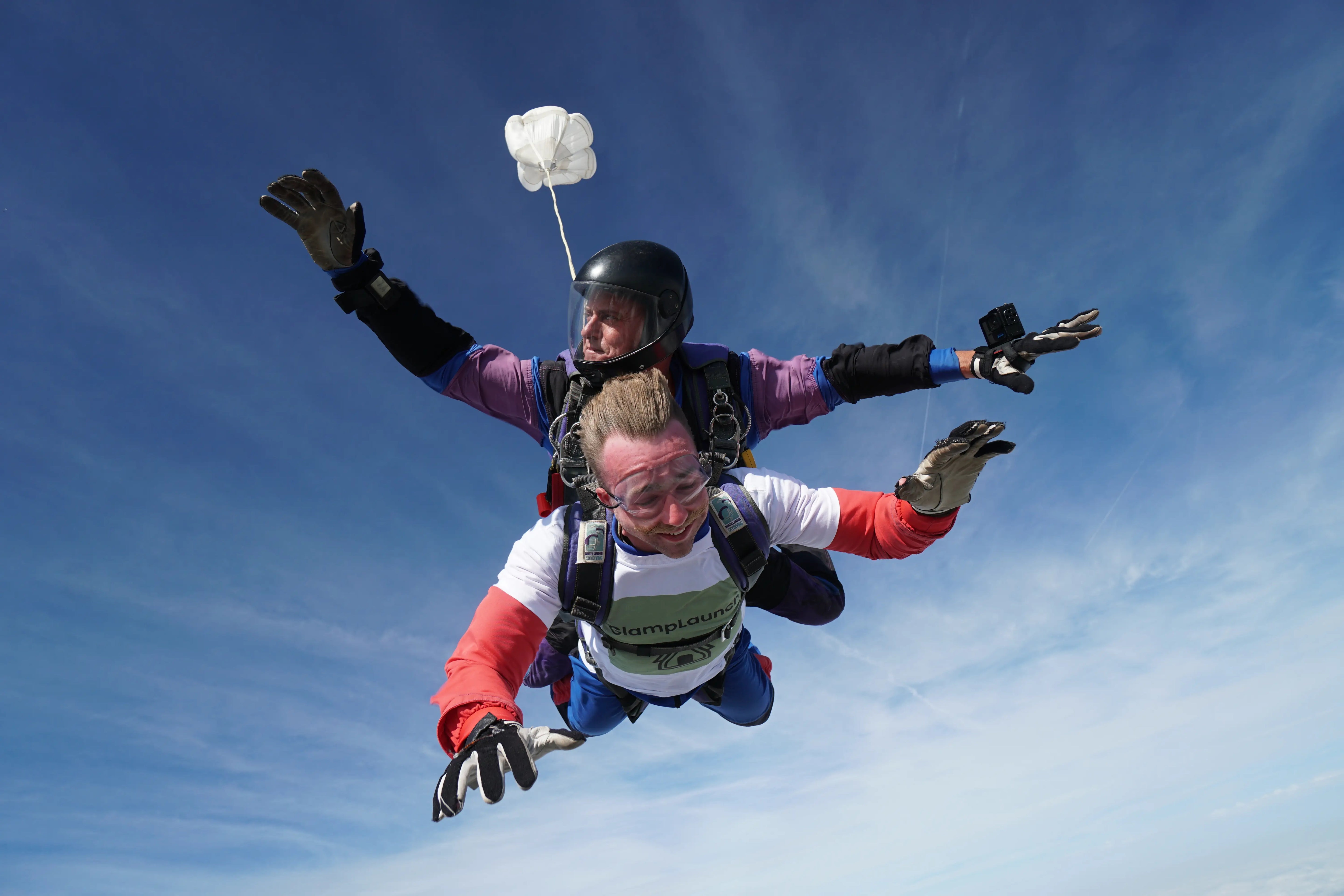 GlampLaunch founder Taylor Glass skydiving in a branded t-shirt, demonstrating fearless leadership and disruptive factory-direct marketing compared to £60k showroom competitors.