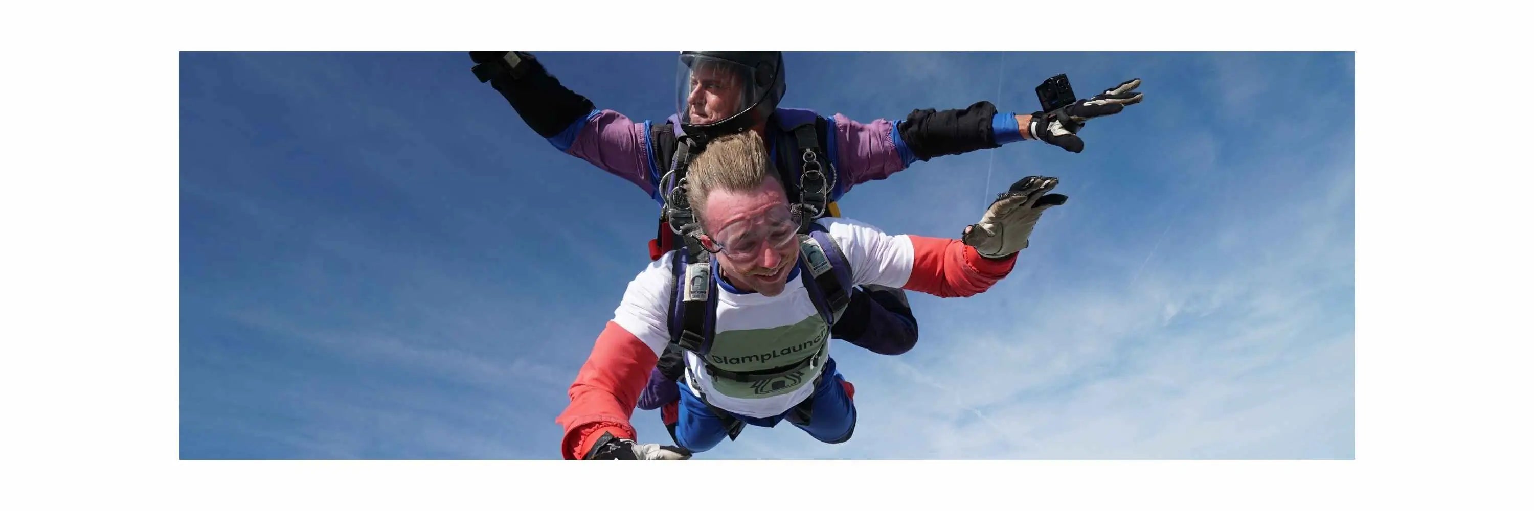 GlampLaunch founder Taylor Glass skydiving in a branded t-shirt, demonstrating fearless leadership and disruptive factory-direct marketing compared to £60k showroom competitors.