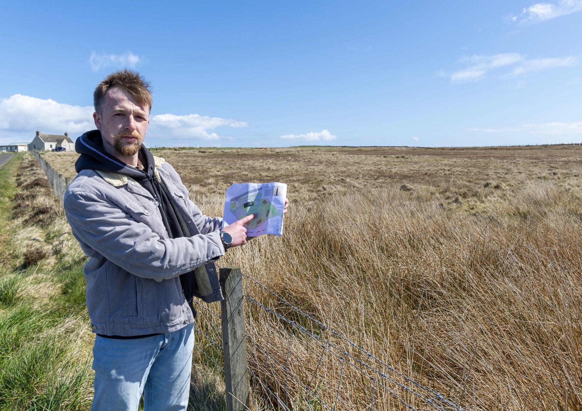Taylor Glass reviewing a masterplan drawing on site at the John O'Groats development in Scotland during feasibility and planning assessment for a large hospitality project.