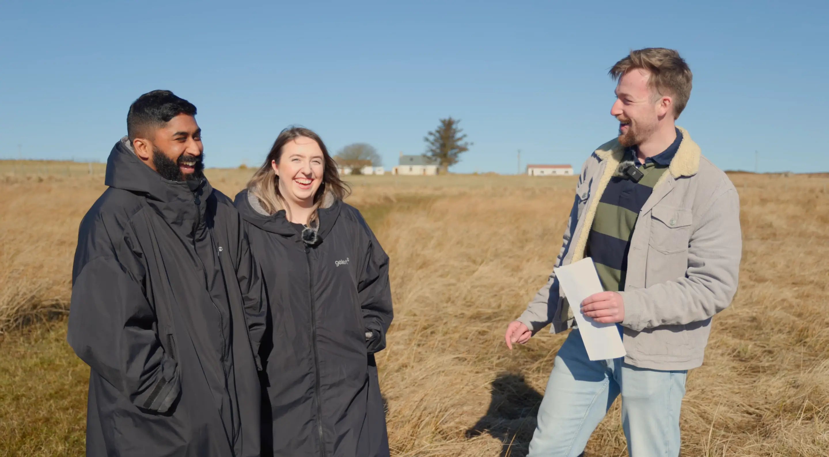 Taylor Glass, founder of GlampLaunch, laughing with clients during a site visit at a proposed glamping development. The image captures the genuine relationships, trust, and personal support built throughout the journey from initial idea to successful glamping site launch.