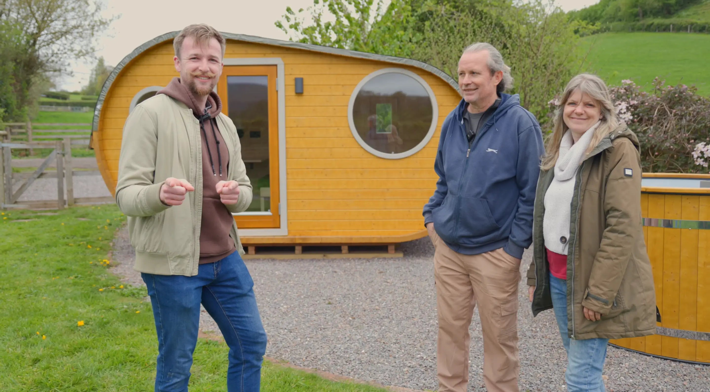 Taylor Glass with Jon and Clare Kelly of Steaming Stars Glamping in Somerset, sharing their customer testimonial after purchasing a Grotto glamping pod from GlampLaunch. The image reflects real client success, trust, and the personalised support provided throughout the glamping site development process.